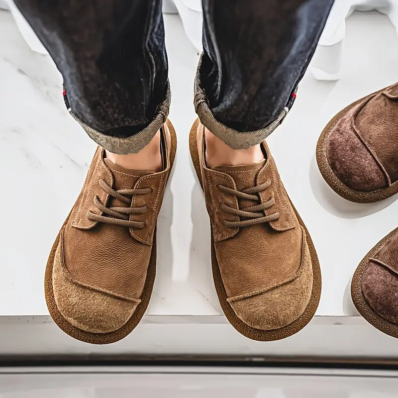 Blick von oben auf die getragenen hellbraunen Schnürschuhe mit runder Kappe und breiter Sohle, daneben ein dunkleres Paar. 4
