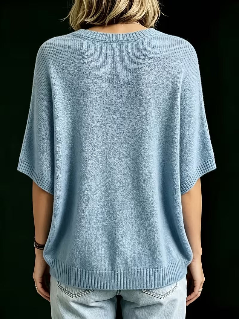 Rückansicht des hellblauen Strickoberteils mit Rundhalsausschnitt, gerippten Ärmelabschlüssen und Saum, getragen mit heller Jeans. 14