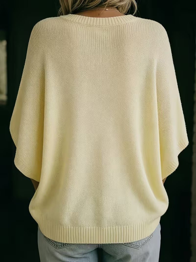 Rückansicht des hellgelben Strickoberteils mit gerippten Bündchen an Ausschnitt, Ärmeln und Saum, getragen mit heller Jeans. 6
