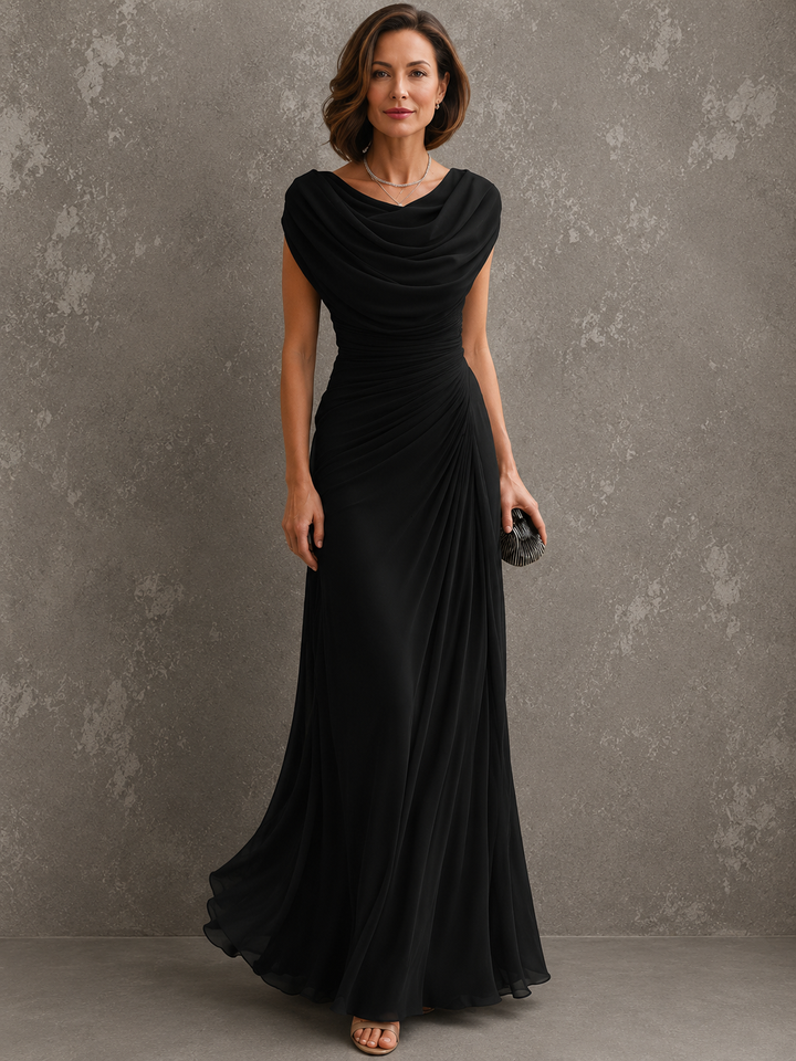 Frontansicht in Schwarz: Model im ärmellosen Kleid mit drapiertem Ausschnitt, gerafftem Oberteil und weit fallendem Rock, Clutch in der Hand. 4