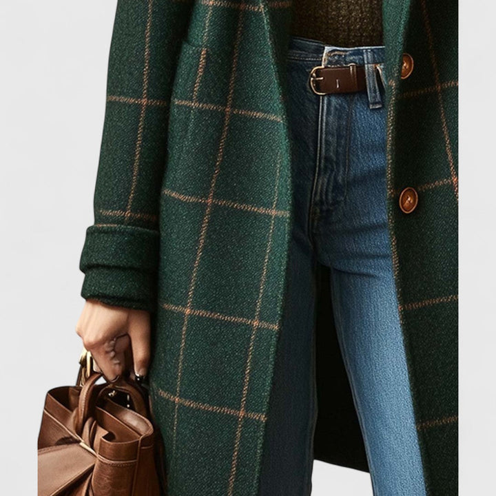 Detailaufnahme der Vorderseite mit aufgesetzter Tasche, umgeschlagener Manschette, Knöpfen und der in der Hand gehaltenen braunen Ledertasche. 4