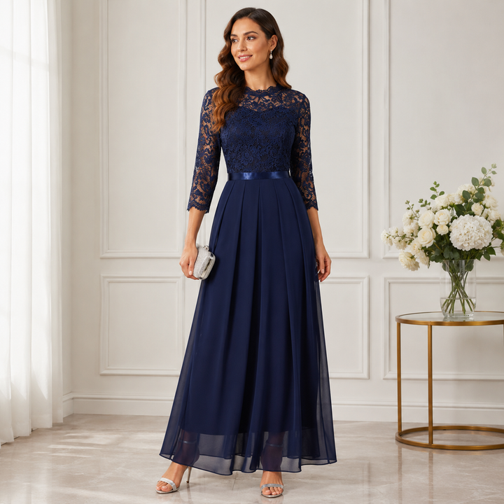Dunkelblaues Maxikleid mit Spitzenoberteil und plissiertem Chiffonrock, von einer Frau mit silberner Clutch im Salon 2