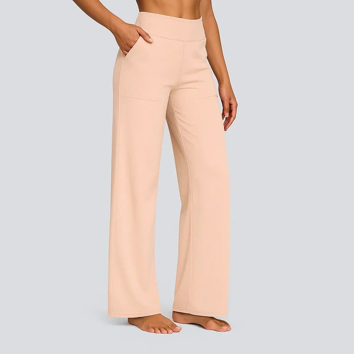 Seitenansicht der Hose in hellem Pfirsich-Beige, getragen von einem Model barfuß mit Hand in der Tasche. 14