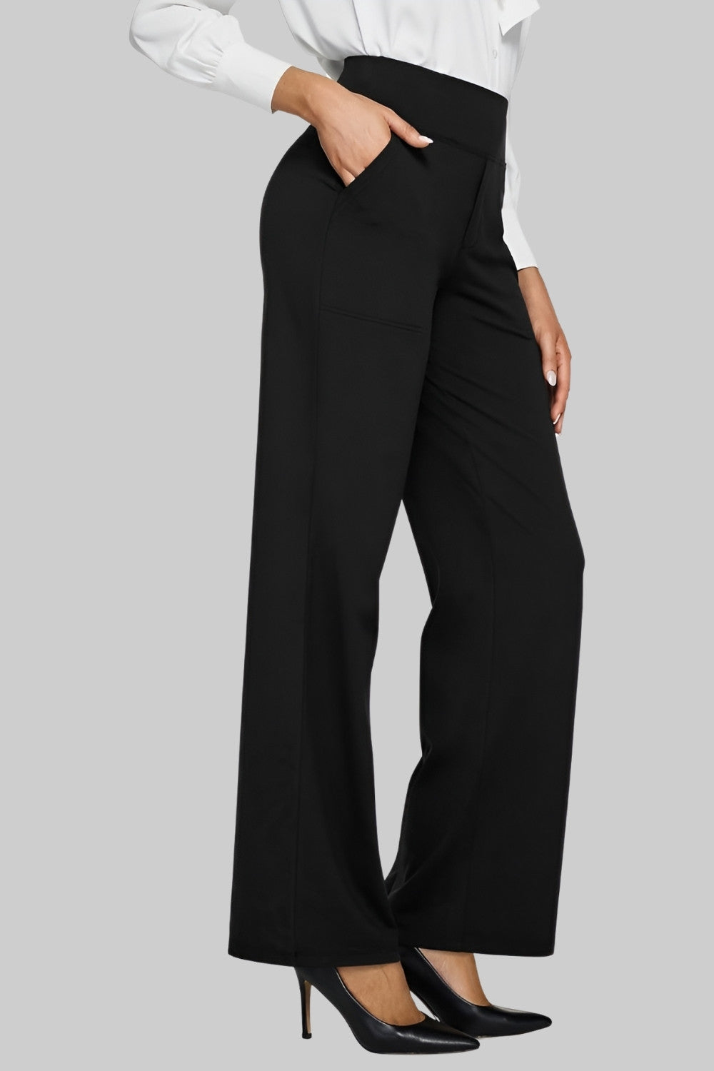 Schwarze Hose kombiniert mit weißer Bluse und schwarzen Pumps, ein businessgeeigneter Look mit Hand in der Tasche. 10