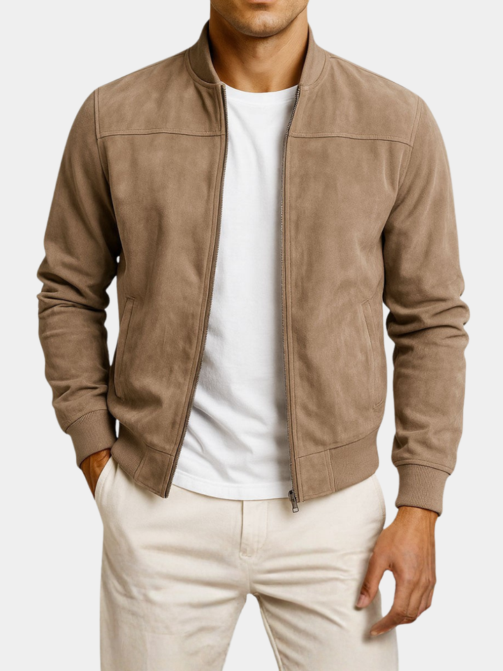 Freigestellte Frontansicht der beigebraunen Jacke an einem Model, offen getragen über weißem Shirt, eine Hand in der Hosentasche. 6
