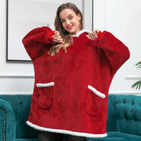Frau in rotem, flauschigem Oversize-Pullover mit weißen Details auf grünem Sofa.