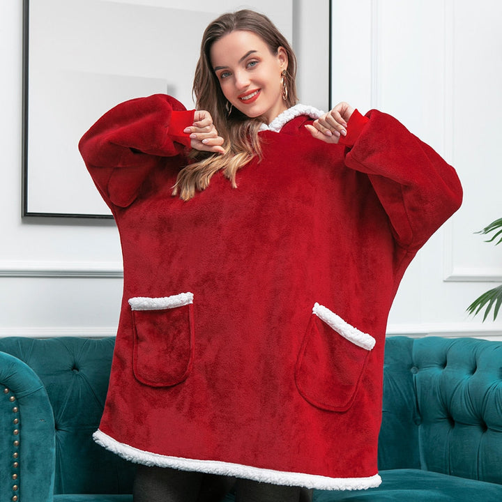 Frau in rotem, flauschigem Oversize-Pullover mit weißen Details auf grünem Sofa.