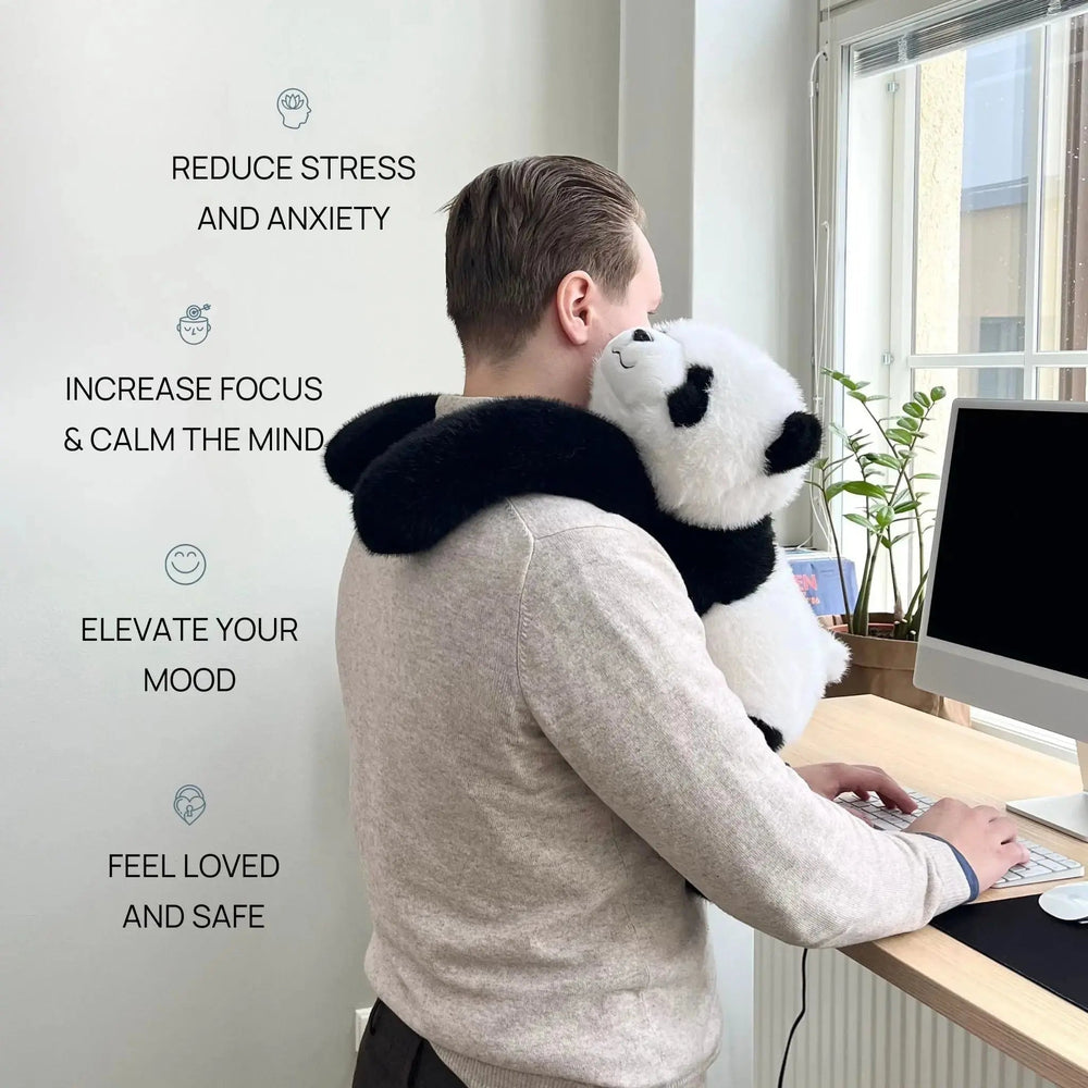 Mann steht am Schreibtisch und trägt den Panda mit den langen Armen wie einen Schal um die Schultern. 2