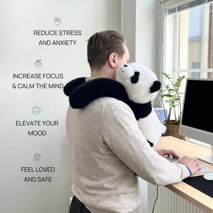 Mann steht am Schreibtisch und trägt den Panda mit den langen Armen wie einen Schal um die Schultern. 2