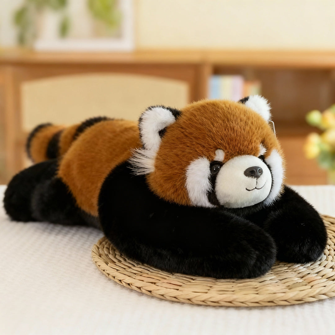 Roter-Panda-Kuscheltier mit rotbraunem Fell, geringeltem Schwanz und langen schwarzen Armen liegt auf einer Strohmatte. 13