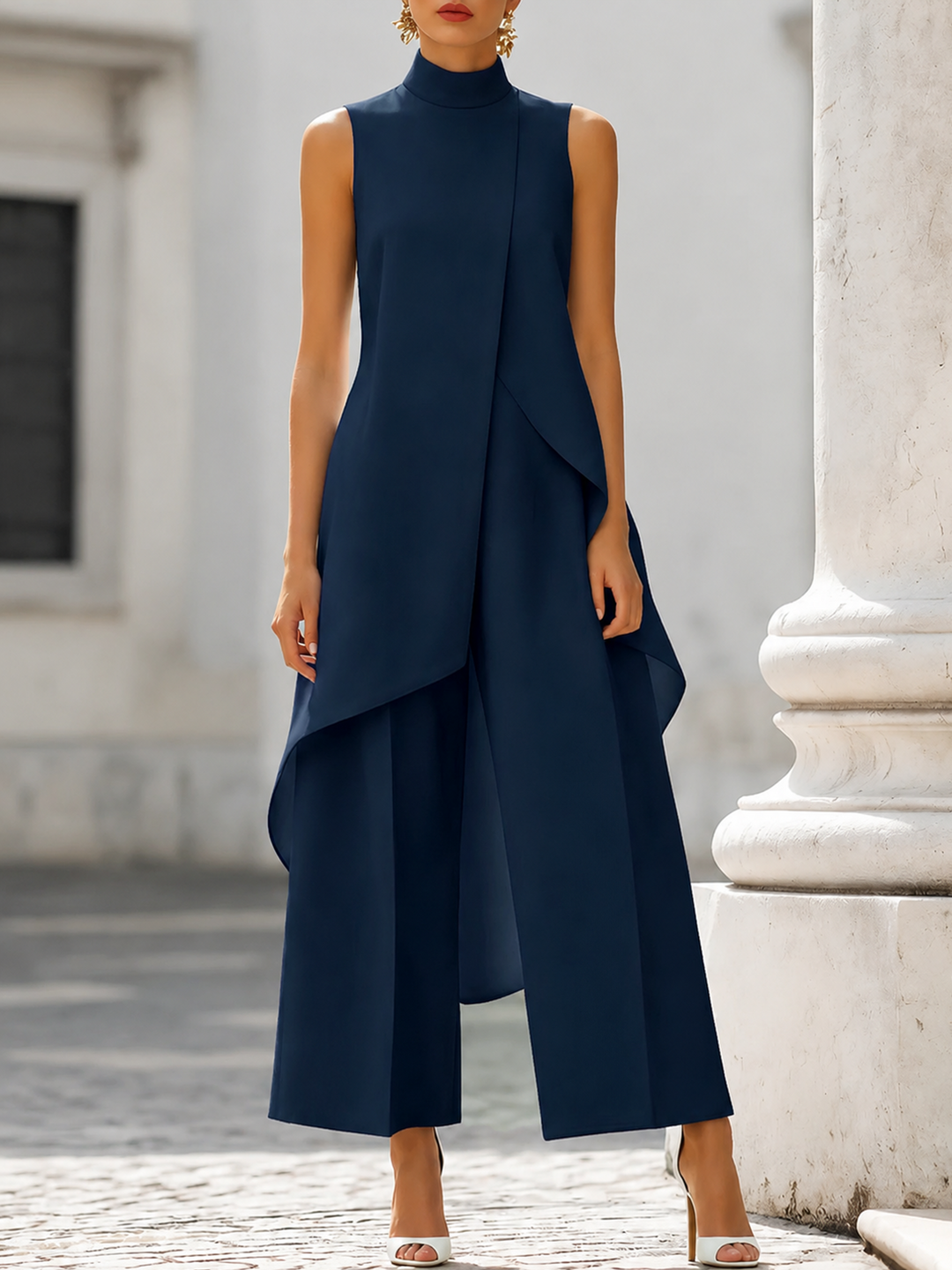 Dunkelblaues Set mit ärmellosem asymmetrischem Oberteil und Hose mit weitem Bein, frontal getragen mit weißen Sandaletten. 6