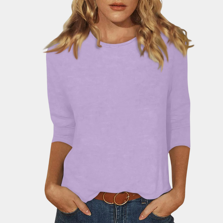 Frau in lila Bluse, 3/4-Ärmel, lässig, Baumwolle, modisch, Damenmode, Freizeitkleidung.
