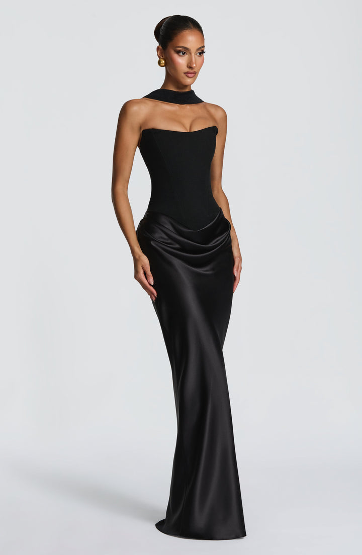 Schwarzes Kleid in Dreiviertelansicht, getragen mit einem hohen schwarzen Kragenband am Hals und goldenen Ohrringen 21
