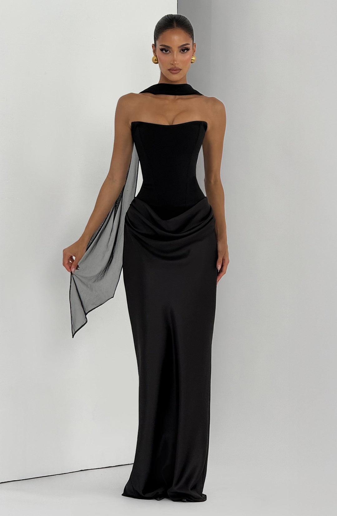 Schwarzes Kleid mit einem langen transparenten Tüllband über einer Schulter, Model hält das Band mit der Hand 27