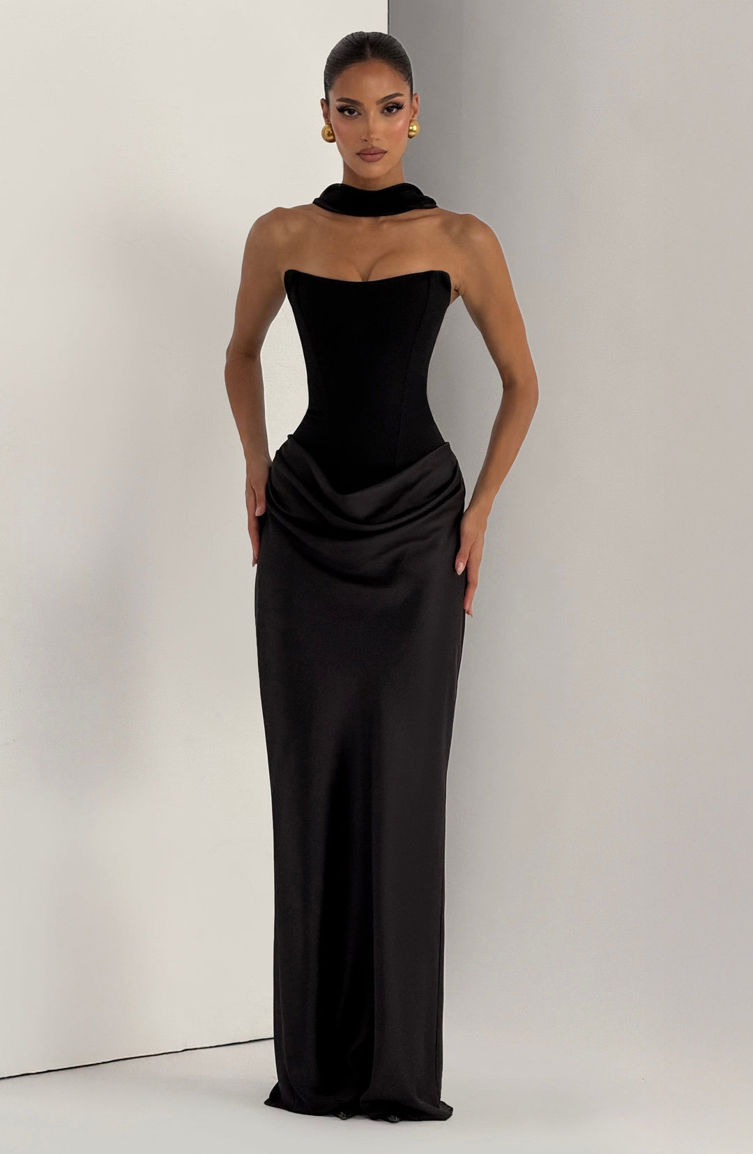 Schwarzes Kleid frontal mit hohem Kragenband am Hals, Model vor hellgrauer Wand 26