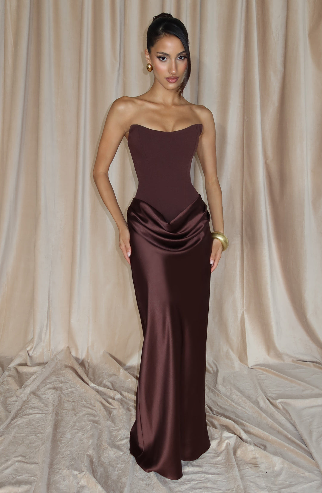 Braunes Korsettkleid mit Wasserfalldrapierung, Model steht frontal vor beigen Vorhängen 8