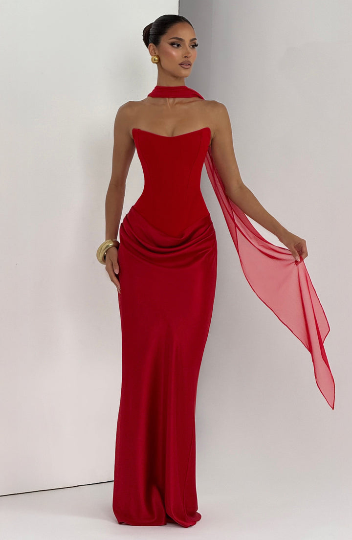 Model in rotem Kleid mit Halsband und lang herabfallendem Schal, goldener Armreif am Handgelenk 19