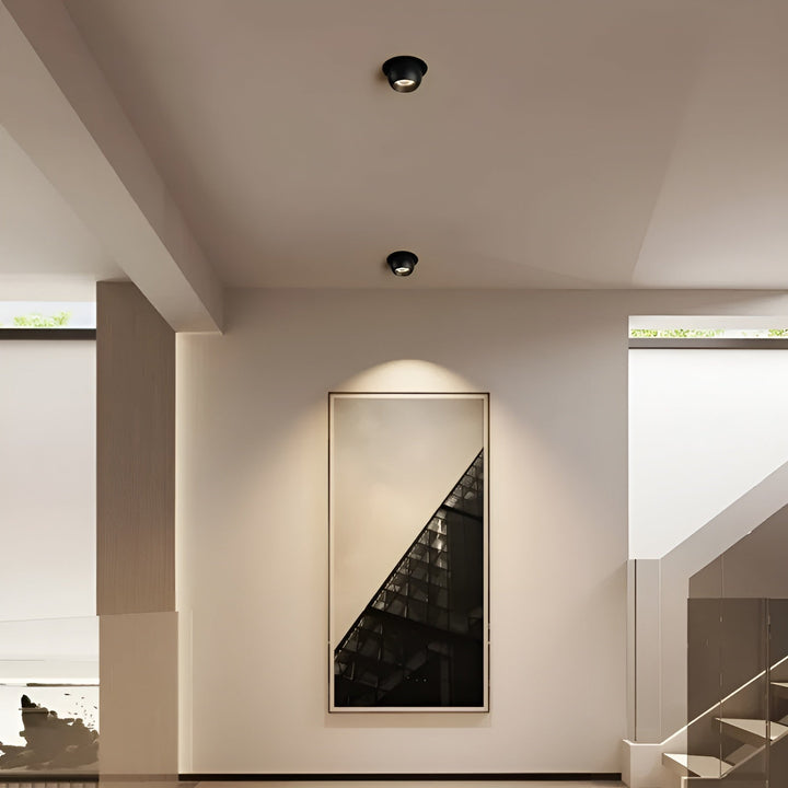 Zwei schwarze Einbaustrahler in der Decke eines Flurs setzen ein großes Wandbild am Treppenaufgang in Szene 3