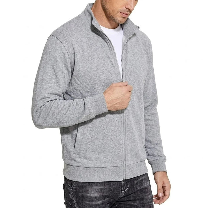 Hellgraue Sweatshirt-Jacke in Schrägansicht, am Reißverschluss gegriffen, mit Stehkragen, Rippbündchen und seitlicher Eingriffstasche. 2