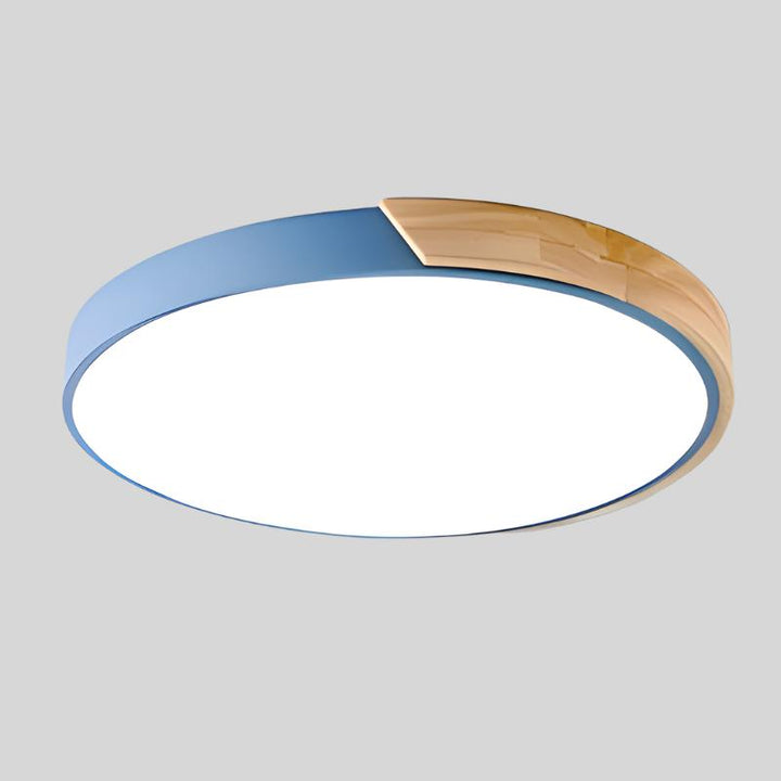 Blaue LED-Deckenleuchte mit eingesetztem Holzsegment am Rand, freigestellt vor hellgrauem Hintergrund. 14