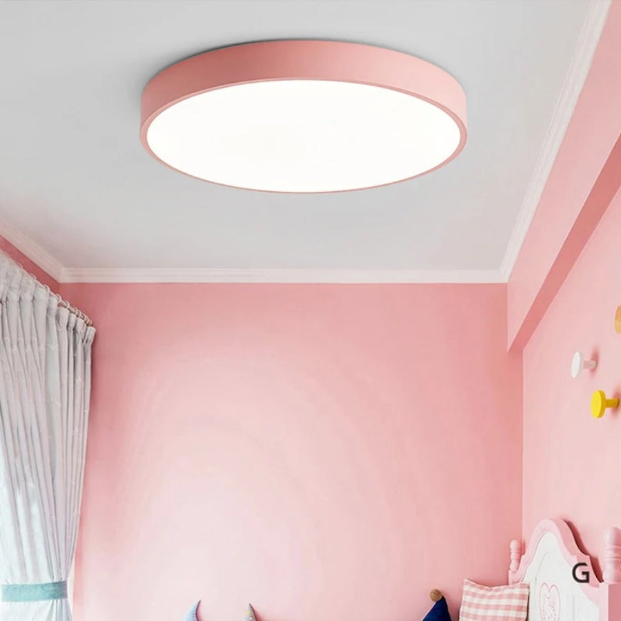 Rosafarbene flache Deckenleuchte in einem rosa Kinderzimmer mit Vorhang, Wandhaken und Kopfteil eines Bettes. 5