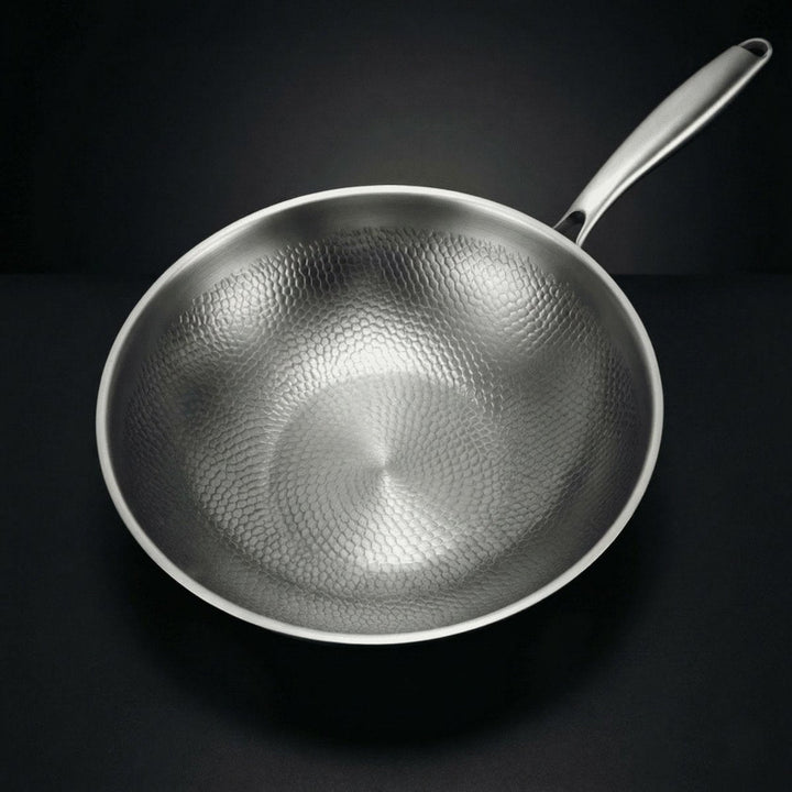 Draufsicht auf die leere Wokpfanne, die das schuppenartige Hammerschlagmuster im Inneren und den Metallgriff zeigt. 2