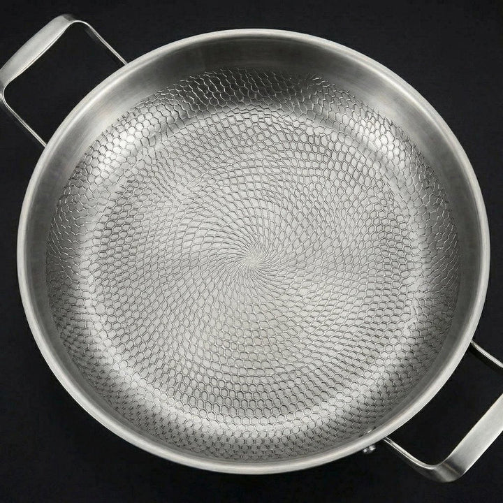 Draufsicht auf die leere Pfanne, die das spiralförmige, wabenartige Hammerschlagmuster im Innenboden in Nahaufnahme zeigt. 2