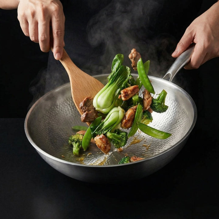 Zwei Hände rühren mit einem Holzwender Pak Choi, Brokkoli, Zuckerschoten und Fleisch in der dampfenden gehämmerten Pfanne. 7
