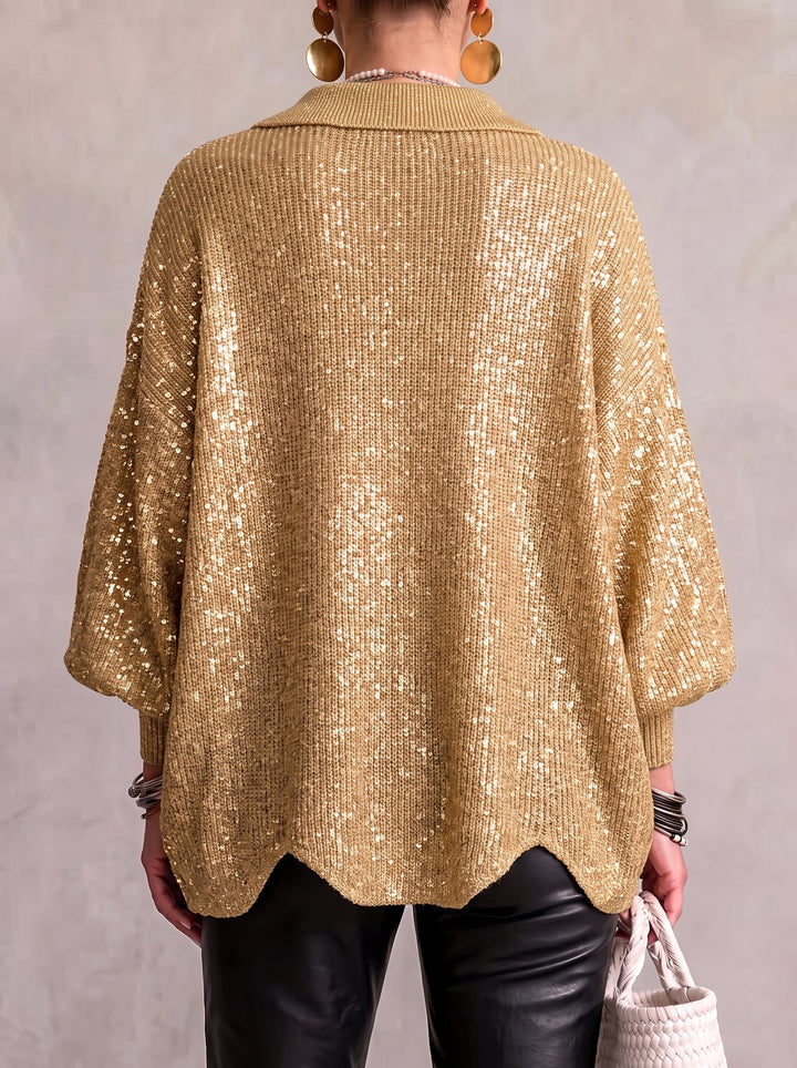 Rückansicht der goldfarbenen Paillettenstrickjacke mit gewelltem Saum, getragen zu schwarzer Lederhose. 14