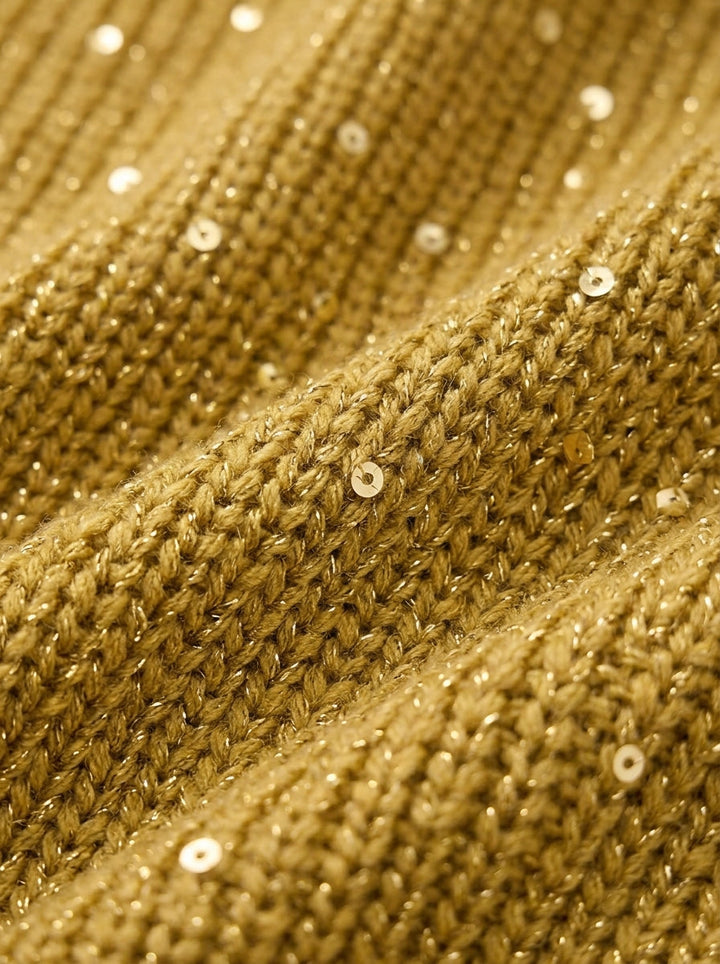 Nahaufnahme des goldfarbenen Strickstoffs mit eingearbeiteten kleinen Pailletten und glitzernden Fäden. 13