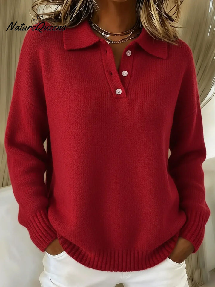 Frau trägt den Strickpullover in Rot, Vorderansicht mit Polokragen, Knopfleiste und gerippten Ärmelbündchen, kombiniert mit weißer Hose. 3
