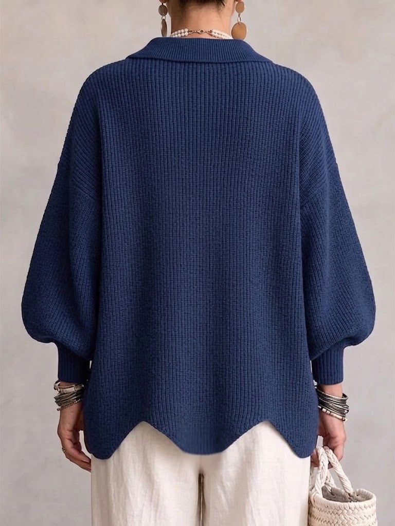 Rückansicht der marineblauen Strickjacke mit Rippstrick, weiten Ballonärmeln und gewelltem Saum. 16