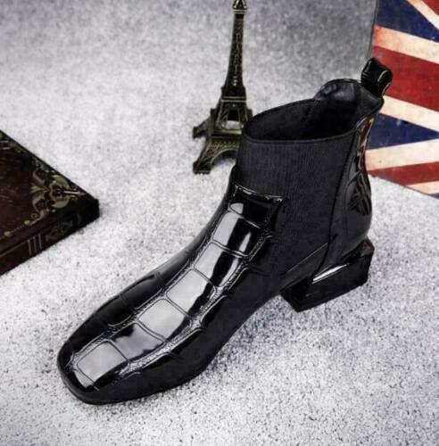 Schwarzer Krokoprägungs-Stiefel mit quadratischer Spitze und Stretcheinsatz von oben links fotografiert, daneben Eiffelturm-Figur und Union-Jack-Dekoration. 5