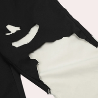 Schwarze zerrissene Jeans, Nahaufnahme, modisches Design, weiße Unterlage sichtbar.