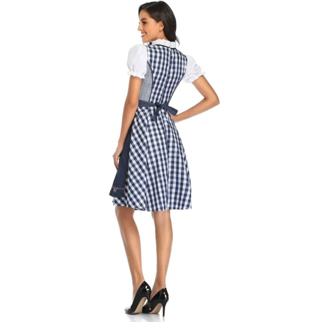 Rückenansicht des blau-weiß karierten Dirndls mit dunkelblauer Schürze, im Rücken gebundener Schleife und weißen Puffärmeln. 11