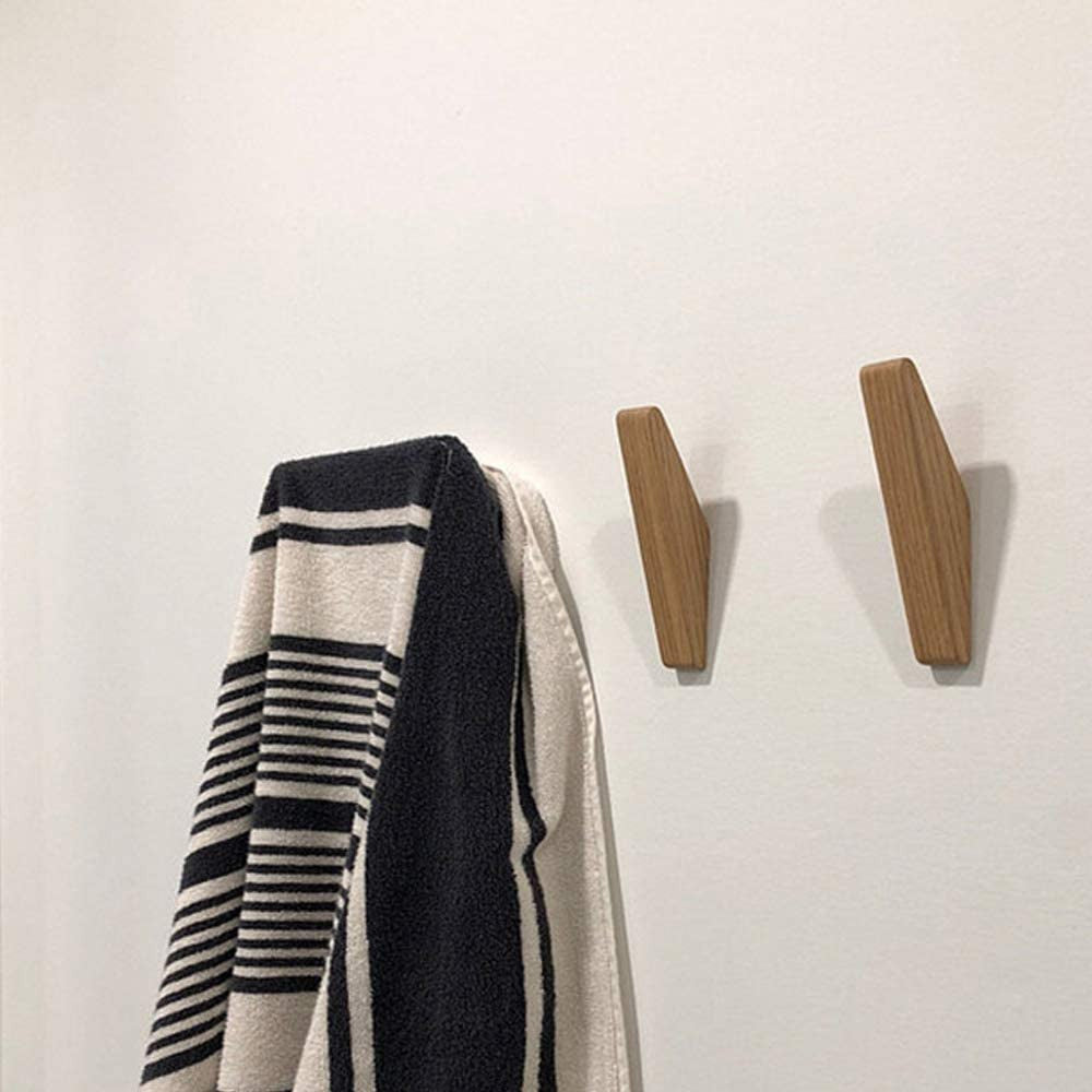 Zwei Holzhaken an einer weißen Wand, an einem hängt ein schwarz-weiß gestreiftes Handtuch, der andere bleibt frei. 4