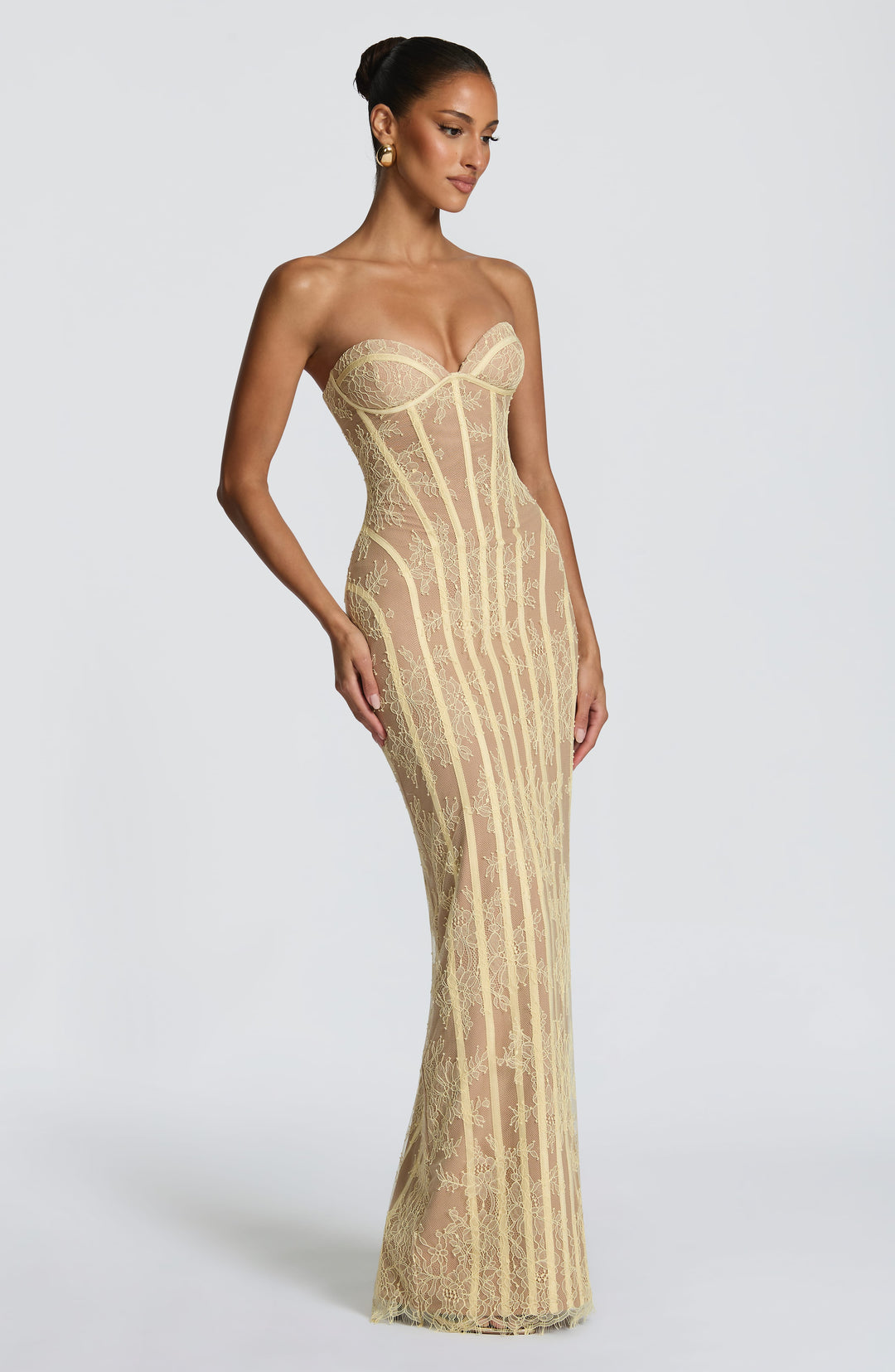 Das gelbe Korsettkleid in seitlicher Dreiviertelansicht, die Herzausschnitt-Cups und die geschwungenen Zierbänder zeigt. 19
