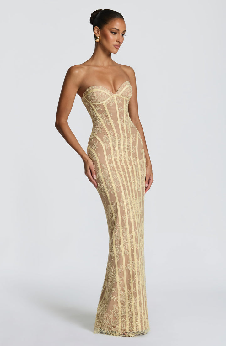 Das gelbe Korsettkleid in seitlicher Dreiviertelansicht, die Herzausschnitt-Cups und die geschwungenen Zierbänder zeigt. 19