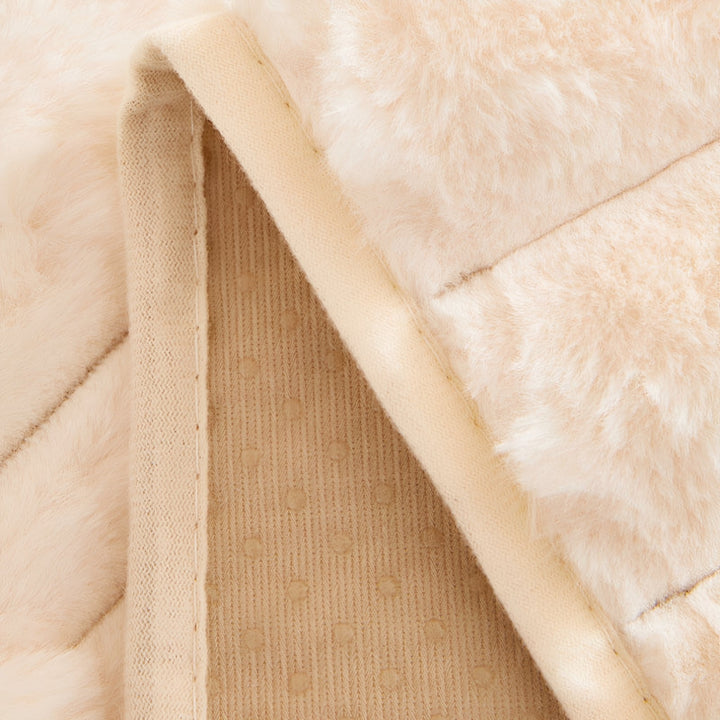 Umgeschlagene Kante der Sofahusse zeigt die beige Unterseite mit rutschhemmenden Punkten und die Naht neben dem Plüschflor. 6