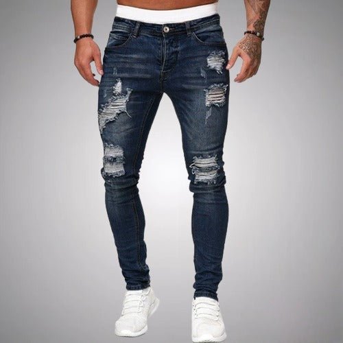 Frontansicht der zerrissenen Jeans in dunklem Marineblau, schmal geschnitten, mit weißen Sneakern getragen und mit Rissen an Oberschenkeln und Knien. 4