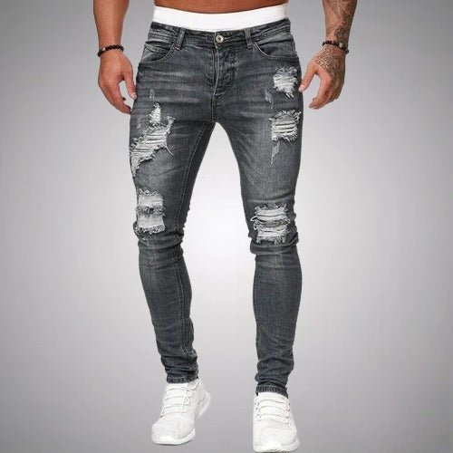 Frontansicht der Distressed-Jeans in ausgewaschenem Anthrazitgrau, eng geschnitten, mit weißen Sneakern getragen und mit Rissen an Oberschenkeln und Knien. 5