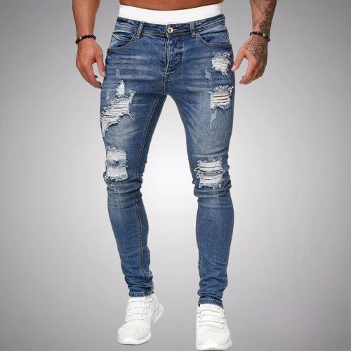 Frontansicht der Distressed-Jeans in mittlerem Blau, eng geschnitten und mit weißen Sneakern kombiniert, mit Rissen an Oberschenkeln und Knien. 3