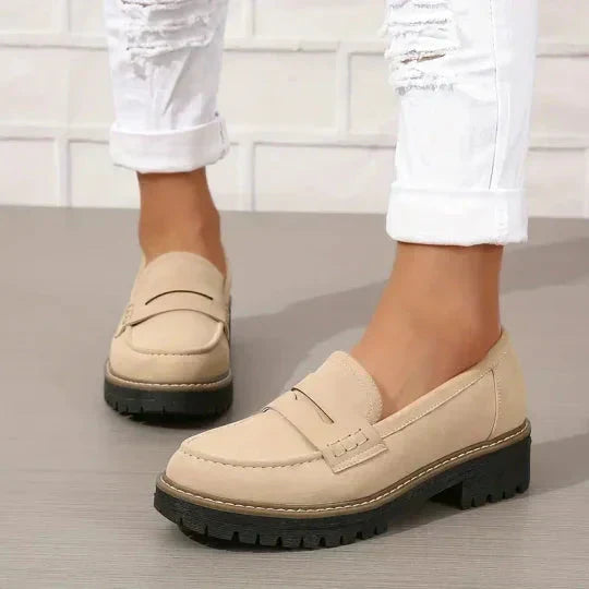 Beige Loafer mit schwarzer Profilsohle, getragen zu weißer Hose mit umgeschlagenem Saum. 7