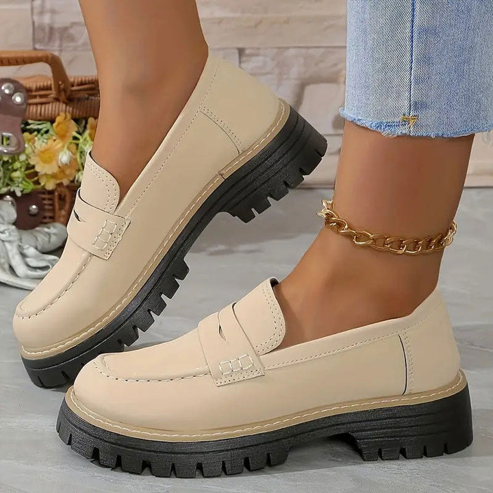 Beige Loafer mit glatter Oberfläche und schwarzer Plateausohle, getragen mit goldener Fußkette zu Jeans. 14