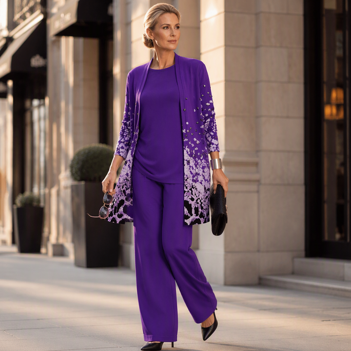 Model in der violetten Variante auf einer Stadtstraße, mit Clutch und Sonnenbrille in der Hand, langer Cardigan mit Pailletten-Print. 12