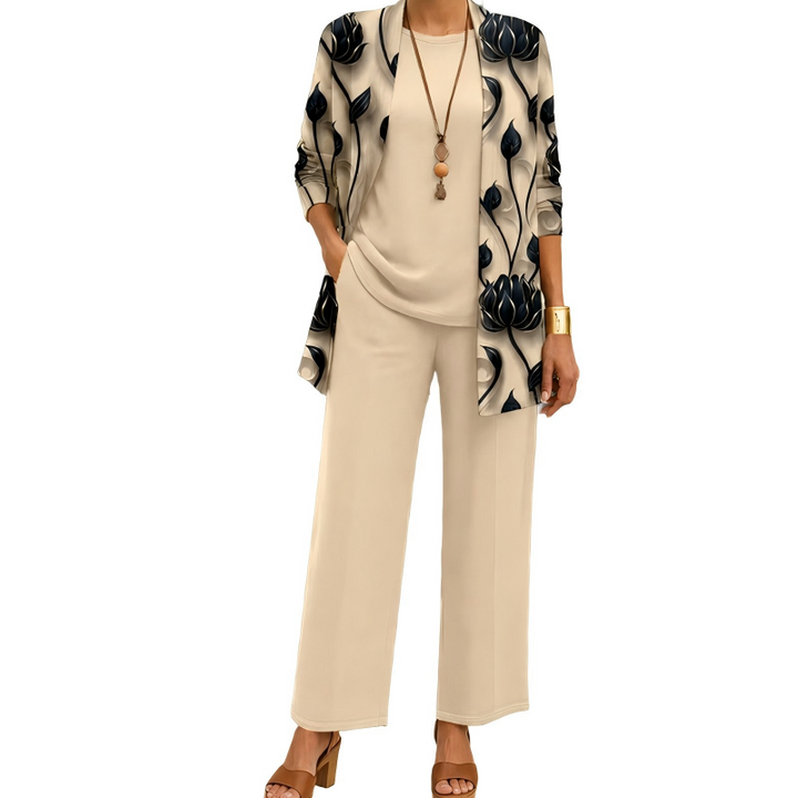Frontansicht des Sets in Beige: langer Cardigan mit schwarzem Blütenmuster über Rundhalsshirt und weiter Hose, dazu Halskette und Armreif. 1