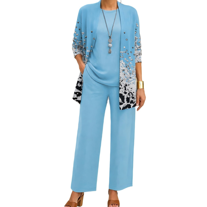 Frontansicht des Sets in Hellblau: Cardigan mit silbernen Pailletten und schwarz-weißem Print am Saum, passendes Shirt und weite Hose. 11