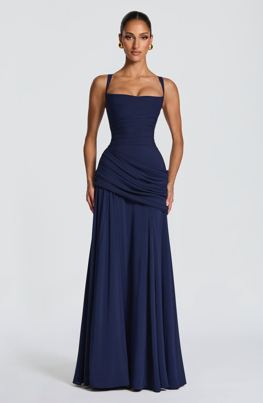 Marineblaues Maxikleid von vorn mit eckigem Ausschnitt, breiten Trägern und drapiertem Hüftteil, Model mit Goldohrringen. 5