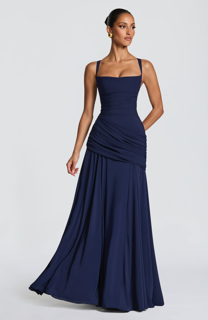 Marineblaues Kleid in leichter Drehung, der Chiffonrock schwingt seitlich aus, Model blickt zur Seite. 8