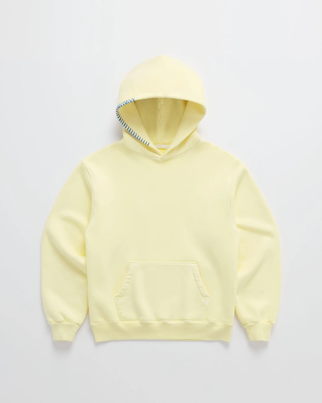 Hellgelber Kapuzenpullover von vorn auf hellem Grund, mit Känguru-Tasche und blauer Ziernaht am Kapuzenrand. 1